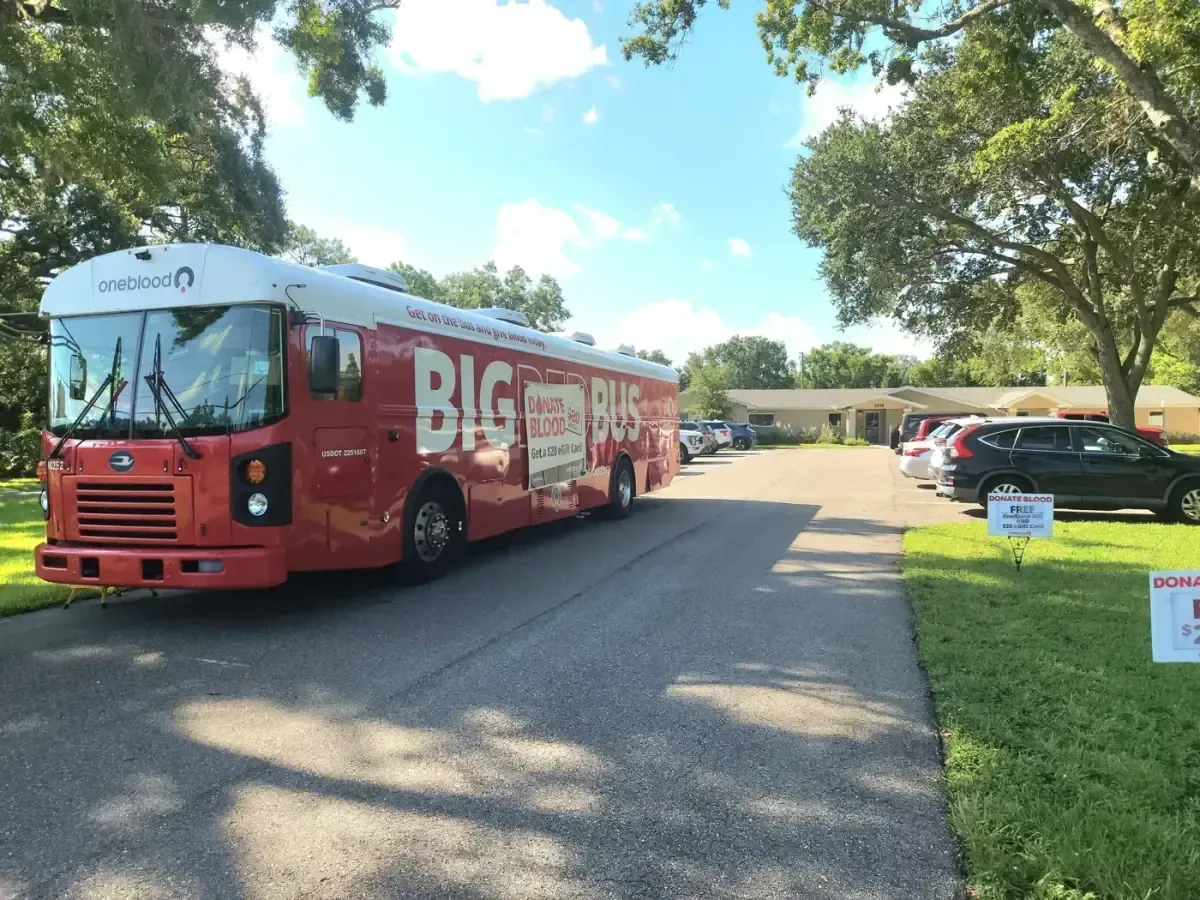 A OneBlood blood donation bus parked outside Gregory Veterinary Clinic during a community blood drive